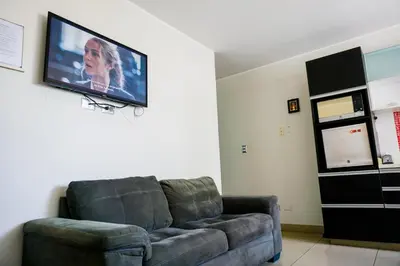 a living room with a couch and a flat screen tv at Apart Hotel Petit Palace Suites in Lima