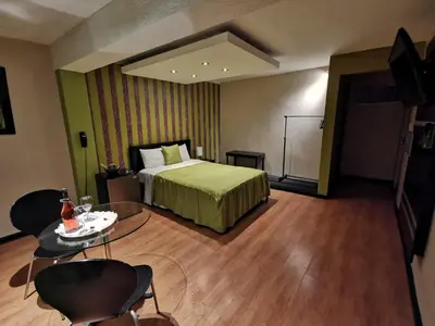 a hotel room with a bed and a table and chairs at Fantasy Suites in Lima