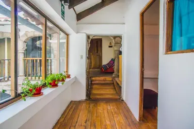 a hallway of a house with wooden floors and windows at Tucan Hostel in Cusco