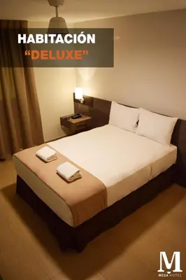 a bedroom with a bed with two towels on it at Hotel Mega in Lima