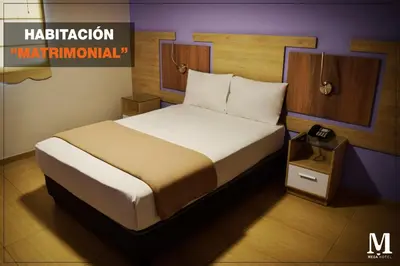 a bedroom with a large bed with a night stand at Hotel Mega in Lima