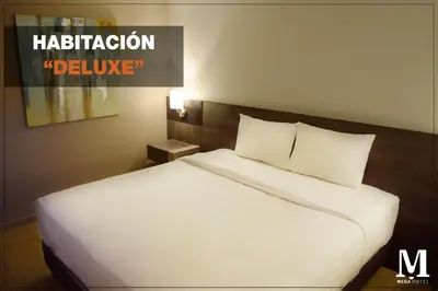 a large white bed in a hotel room at Hotel Mega in Lima