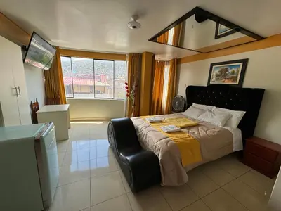 a bedroom with a large bed and a window at Illari Wari l - Hotel Sauna in Ayacucho
