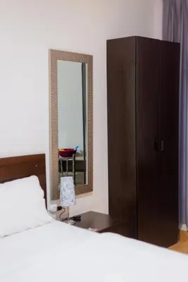 a bedroom with a bed and a dresser and a mirror at Hotel Venture in Chincha Alta