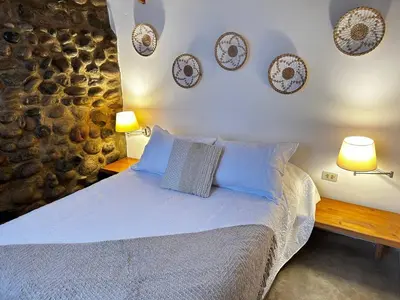 a bedroom with a bed with blue pillows and plates on the wall at Villas de Cieneguilla in Cieneguilla