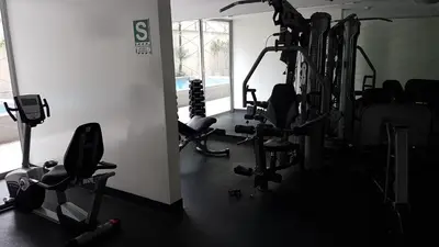 a gym with several tread machines in a room at Lima Flats 3 in Lima