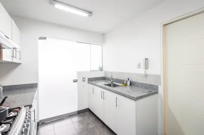 a kitchen with white cabinets and a sink at InkaHuset Miraflores Deluxe in Lima
