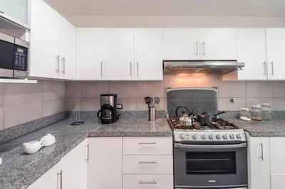 a kitchen with white cabinets and a stove top oven at InkaHuset Miraflores Deluxe in Lima