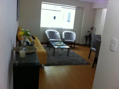 a living room with a couch and a table and chairs at Departamento Miraflores in Lima