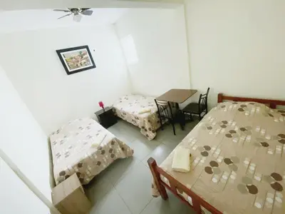 a room with two beds and a table and chairs at Lima House Hostel in Lima