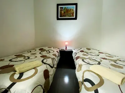 two beds in a room with a candle on a table at Lima House Hostel in Lima