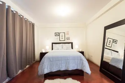 a bedroom with a bed and a large mirror at InkaHuset Airport in Lima