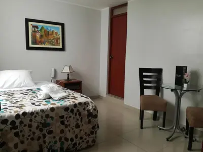 a bedroom with a bed and a table and a chair at PiscoMar Peru in Pisco