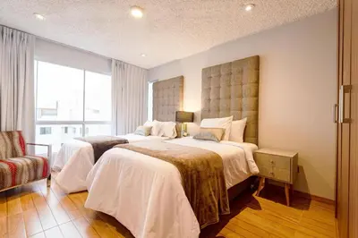 a hotel room with two beds and a window at OceanFront Larcomar Apartments in Lima