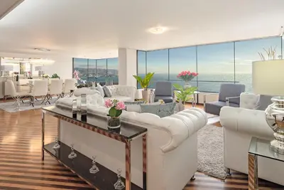 a living room with white furniture and large windows at OceanFront Larcomar Apartments in Lima