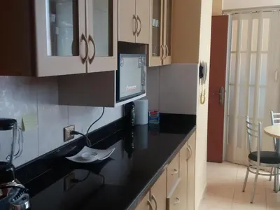 a kitchen with a black counter top and white cabinets at Miraflores in Lima