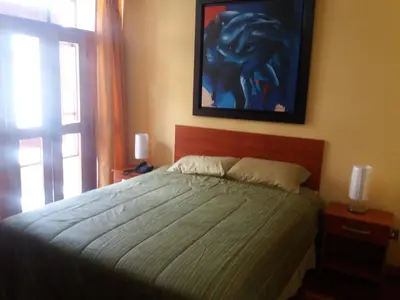 a bedroom with a bed and a painting on the wall at Miraflores in Lima