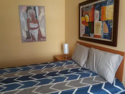 a bedroom with a bed and a painting on the wall at Miraflores in Lima