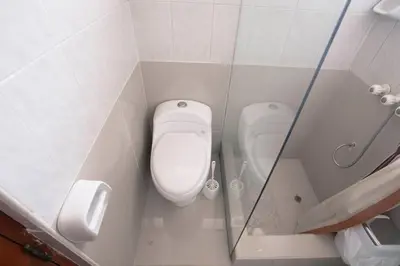 a bathroom with a toilet and a glass wall at Family House in Lima