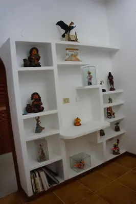 a white book shelf with stuffed animals on it at Family House in Lima