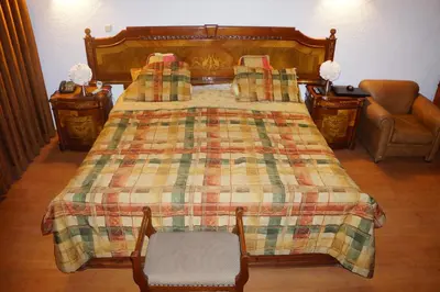 a bedroom with a bed with a blanket and a chair at Family House in Lima