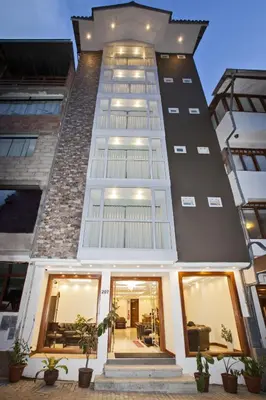 a tall building with windows and plants in front of it at Jaya Machu Picchu Boutique Hotel in Machu Picchu