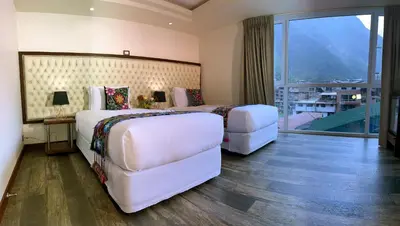 a hotel room with two beds and a balcony at Jaya Machu Picchu Boutique Hotel in Machu Picchu