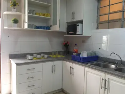 a kitchen with white cabinets and a sink at Kelebek Hostel in Lima