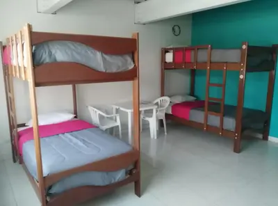 a room with two bunk beds and a table at Kelebek Hostel in Lima