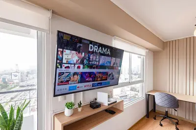 a flat screen tv hanging on a wall in a room at ALU Apartments - Limit with Miraflores Panoramic City View in Lima