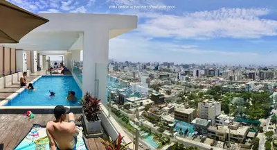 a man in a swimming pool on top of a building at ALU Apartments - Limit with Miraflores Panoramic City View in Lima