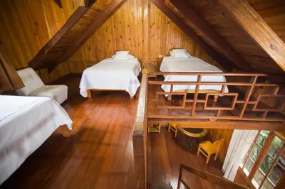 a room with two beds in a attic at Cemayu Lodge in Oxapampa