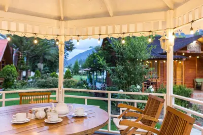 a wooden table and chairs on a porch at Cemayu Lodge in Oxapampa
