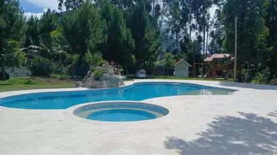 a large swimming pool in a yard with trees at Cemayu Lodge in Oxapampa