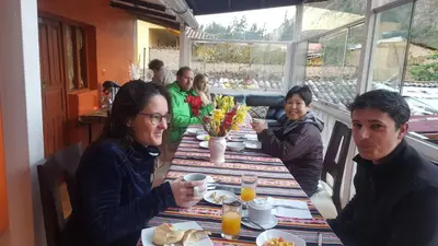 a group of people sitting at a table in a restaurant at Killari B&B in Ollantaytambo
