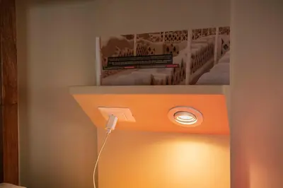 a light on a wall with a picture on top at Pariwana Hostel Lima in Lima