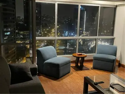a living room with a view of a city at night at Oceanfront Miraflores Larcomar next to Marriott in Lima