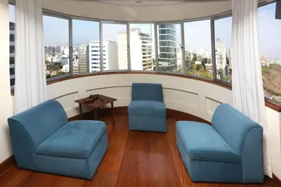 two chairs and a table in a room with windows at Oceanfront Miraflores Larcomar next to Marriott in Lima