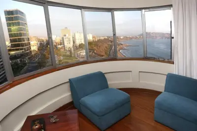 a room with two chairs and a table and windows at Oceanfront Miraflores Larcomar next to Marriott in Lima