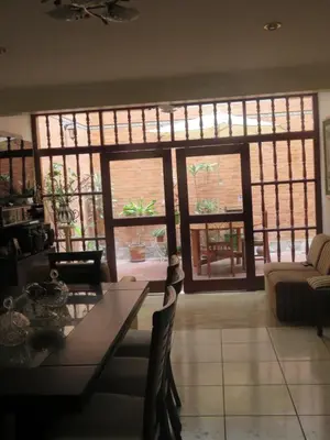 a living room with a table and large windows at Casa particular de Jorge Edinson in Lima