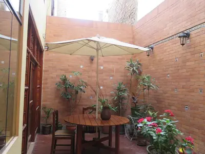 a patio with a table and an umbrella at Casa particular de Jorge Edinson in Lima