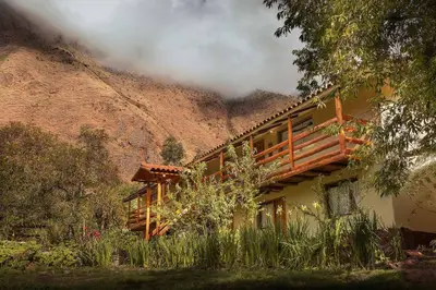 a house with a balcony in front of a mountain at Casita Huaran in Calca