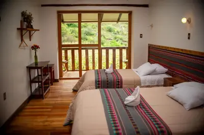two beds in a room with a balcony at Casita Huaran in Calca