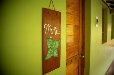 a wooden sign on a green wall with the word nature at Casita Huaran in Calca