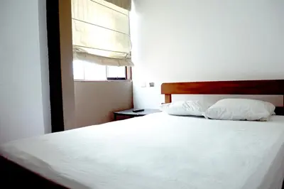 a bedroom with a white bed with two pillows at Hostal Los Angeles in Barranca