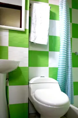 a green and white bathroom with a toilet and sink at Hostal Los Angeles in Barranca