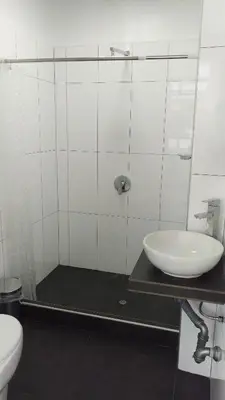 a white bathroom with a sink and a toilet at Hotel Murano in Abancay