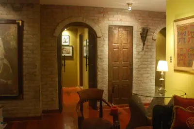 a living room with a door and a brick wall at Black Shark Apartments in Lima