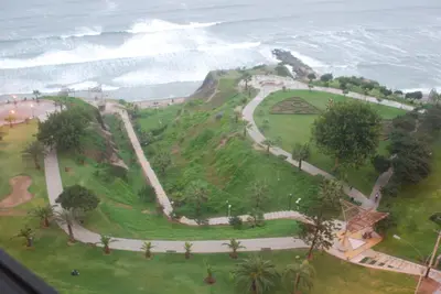 a park on the side of a hill next to the ocean at Black Shark Apartments in Lima