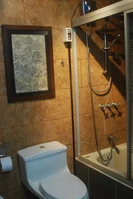 a bathroom with a white toilet and a shower at Black Shark Apartments in Lima